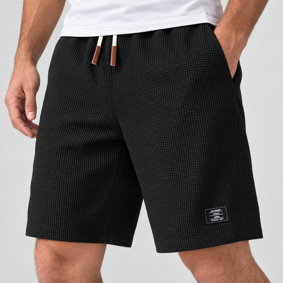 Relaxed Fit Waffle Texture Drawstring Shorts in Black, worn on a model.
